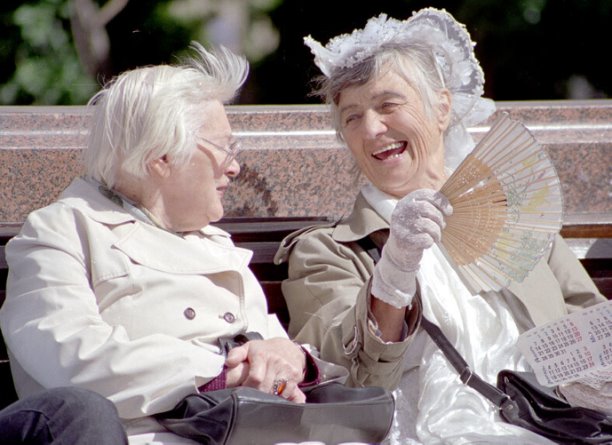Разговор двух женщин, сидящих на скамеечке в парке